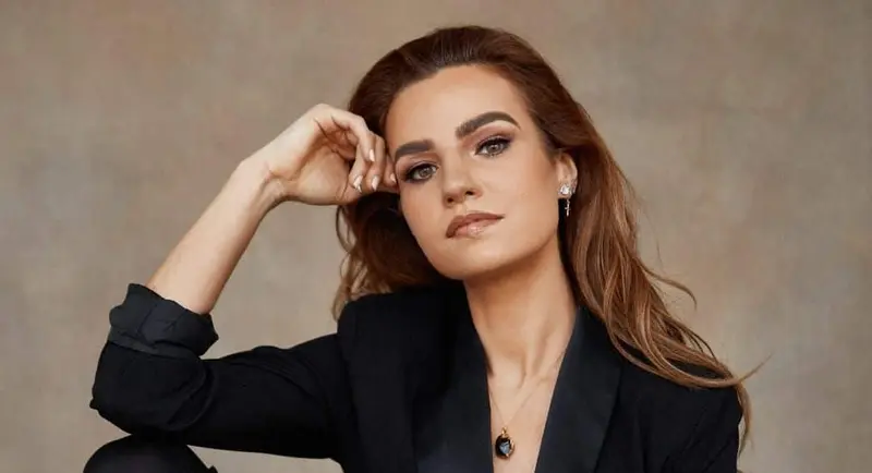 Female DJ in a black tuxedo jacket, studio portrait